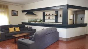 sala de estar con 2 sofás y cocina en Casa La Granda, en Cangas de Onís