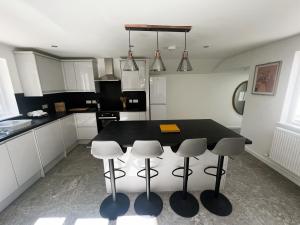 a kitchen with a table and four stools at George Street House in Ryde +25 photos