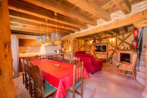 une cuisine et une salle à manger avec une table et des chaises rouges dans l'établissement Los Lebreles Namaste I y II, desconecta en las Hoces del Duratón, à Hinojosas del Cerro