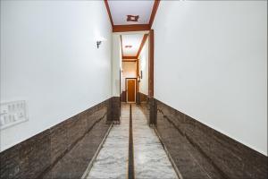un couloir menant à une porte dans un bâtiment dans l'établissement FabHotel Sarwan, à Agra