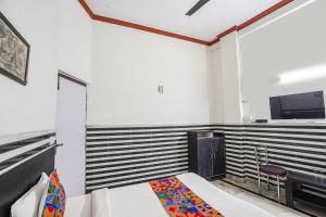 a bedroom with a bed and a desk and a tv at FabHotel Sarwan in Agra