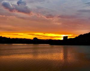 una puesta de sol sobre un gran cuerpo de agua en Apartament 1+1 en Yrsheku