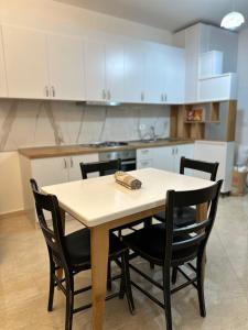 einen Tisch und Stühle in einer Küche mit weißen Schränken in der Unterkunft Apartament 1+1 in Yrsheku