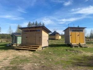 eine Gruppe kleiner Hütten auf einem Feld in der Unterkunft Triangle Cabin in Laitila + 24 Fotos