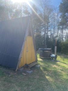 una tienda de campaña y una bañera en un campo en Triangle Cabin, en Laitila