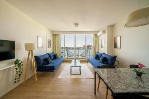 a living room with blue couches and a table at Fliphaus Be Libertador - Lux 1 Bd 11-21 in Buenos Aires