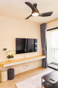 ein Wohnzimmer mit einem TV und einem Deckenventilator in der Unterkunft Luxury Apartment-Vinhomes Grand Park in Gò Công