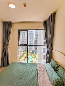ein Schlafzimmer mit einem Bett und einem großen Fenster in der Unterkunft Luxury Apartment-Vinhomes Grand Park in Gò Công