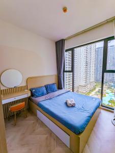 Schlafzimmer mit einem Bett, einem Schreibtisch und einem Fenster in der Unterkunft Luxury Apartment-Vinhomes Grand Park in Gò Công