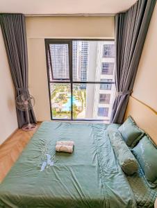Bett in einem Zimmer mit einem großen Fenster in der Unterkunft Luxury Apartment-Vinhomes Grand Park in Gò Công