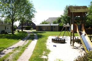 un parque infantil en un patio con tobogán en Chalet Merel en Drijber