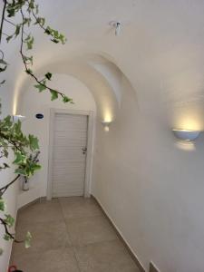 un corridoio con porta bianca e luci sul muro di Villa Pino a Furore