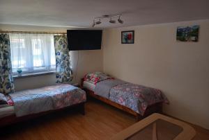 una camera da letto con due letti e una finestra di Apartament pod Szlakiem a Korbielów