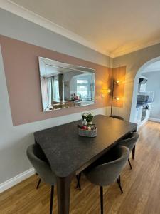 a dining room table with chairs and a mirror at Garden Place in Clevedon