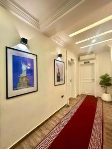 a hallway with a red rug and a picture of the statue of liberty at Extacode Apartments in Abuja