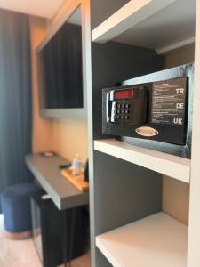 a microwave oven on a shelf in a room at Loft Airport Hotel's in Arnavutköy