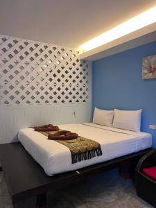 a large bed in a room with a blue wall at Lanta for Rest Boutique in Ko Lanta