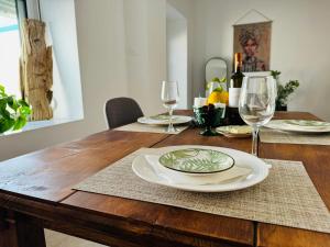 a wooden table with plates and wine glasses on it at Villa FLORA in Kattavía +22 photos