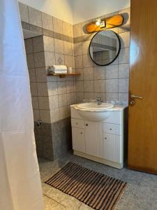 a bathroom with a sink and a mirror at Villa FLORA in Kattavía