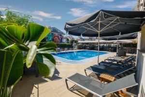 una piscina con sillas, una sombrilla y una piscina en Moni Hotel en Marmaris