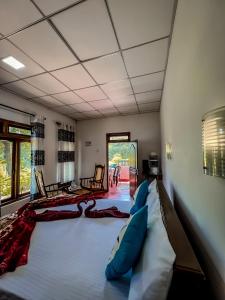 a large bed in a room with two chairs at Ella Willow Cottage in Ella