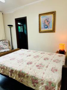 um quarto com uma cama e uma fotografia na parede em Tombo Beach Hostel & Pousada no Guarujá