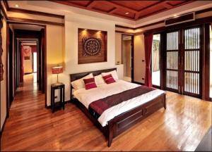 a bedroom with a large bed with red pillows at Large 4 bed villa short walk to Maenam beach in Mae Nam
