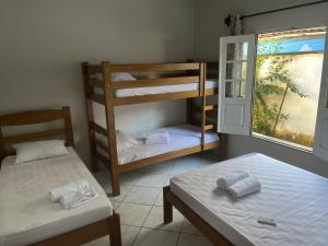 a room with two bunk beds and a window at Casa Dona Amélia in Barreirinhas
