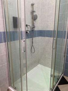 a shower with a glass door in a bathroom at Manì Rooms in Cagliari