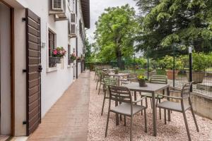 - une rangée de tables et de chaises sur la terrasse dans l'établissement Bilo Garden Agriturismo Teboi, à Pastrengo