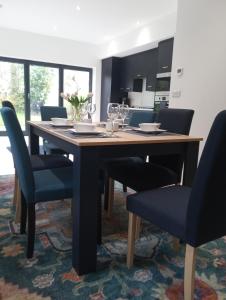 a dining room table with blue chairs in a kitchen at Crossing Cottage sleeps 6 with private parking,ideal for contractors , Newark in Staythorpe
