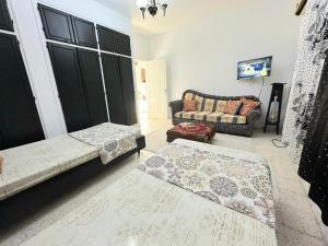 ein Wohnzimmer mit 2 Betten und einem Sofa in der Unterkunft Anis 4 in Sousse