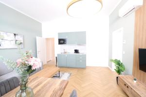 una sala de estar con un jarrón de flores sobre una mesa en Vienna Stay Apartments or Rooms 1050, en Viena