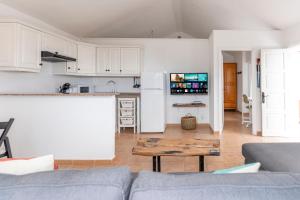 eine Küche und ein Wohnzimmer mit einer Couch und einem Tisch in der Unterkunft Casa El Drago 2 in Breña Baja