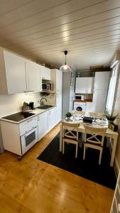 a kitchen with white cabinets and a table at Le Buisson in Le Mont-Dore
