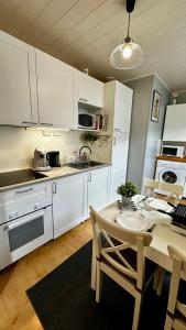 a kitchen with white cabinets and a table with chairs at Le Buisson in Le Mont-Dore