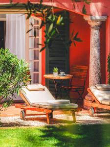a patio with a bed and a table and a chair at Domaine de l'Astragale in Saint-Tropez