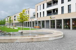 a building with a fountain in the middle of a courtyard at Neues Apartment am Schloßsee Salem in Salem