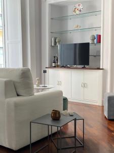 a living room with a white couch and a tv at Portacatena Suite in Salerno
