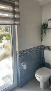 a bathroom with a toilet and a window at Boutique Casa Lapicida in Calpe