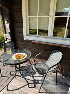 una mesa con un plato de comida y una copa de vino en Bungalo en Jūrmala