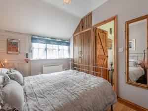 1 dormitorio con 1 cama grande y espejo en Lidsey Farmhouse en Bognor Regis