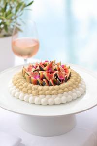 a cake on a white table with a glass of wine at Domaine de l'Astragale in Saint-Tropez