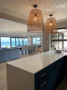una cucina e un soggiorno con due lampadari sopra un bancone di The Cottage a Morgan's Bay