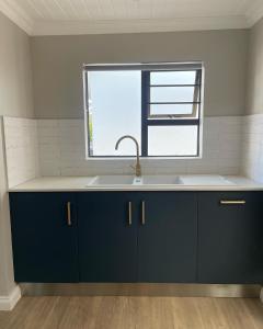 una cucina con un lavandino e una finestra di The Cottage a Morgan's Bay Altre 56 foto
