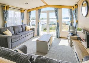 a living room with a couch and a tv at Waters Edge Leisure Park in Cardigan