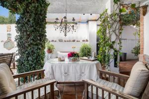 eine Terrasse mit Tisch und Stühlen und Weinreben in der Unterkunft Villa Al Andalus - Solo Familias in El Puerto de Santa María