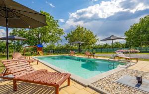 einen Pool mit Stühlen und einem Sonnenschirm in der Unterkunft Lovely Home In Oljasi With Kitchen 