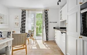 福堡Pet Friendly Home In Faaborg With Wifi的配有白色橱柜、桌子和椅子的厨房