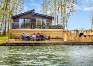 a group of people sitting on a dock with a house at Noahs Retreat in Laceby